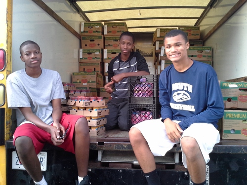 Martin, David and friend loading produce into truck for distribution