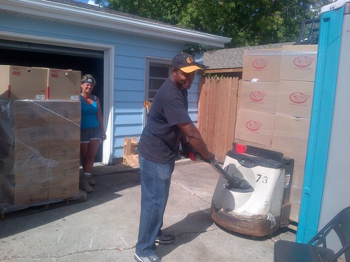 Marilyn looks on as Theo maneuvers a pallet of food with our donated pallet jack 